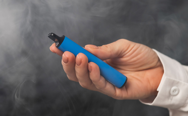Image of hand holding a blue disposable vape device