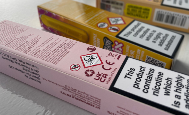A close up of a disposable vape package with warning labels on display