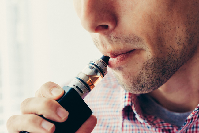 Image of a person inhaling on a vape device