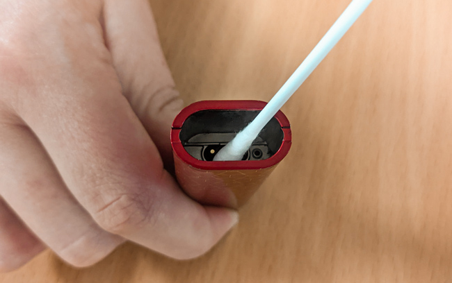 Vape battery terminal being cleaned with a cotton bud