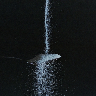 Image of sugar being poured on a spoon