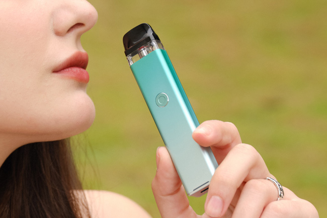 Woman holding an Vaporesso Xros 3 in her hand.