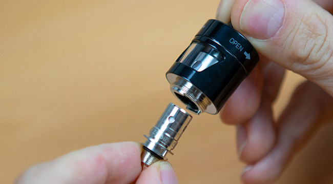 A coil being removed from a vape tank