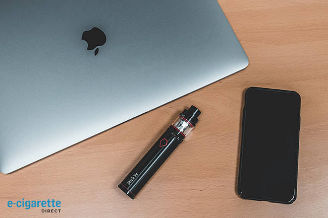 Smok Stick V9 pictured next to a macbook and phone.